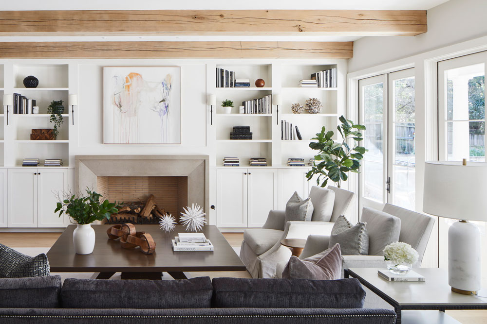 This image features a large great room in Dallas, Texas. With a beautiful Dallas Design, O'Hara Interiors includes features such as a fireplace, built in shelving, and multiple seating options. 